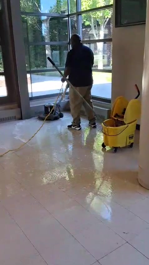 Montoya team member cleaning a tiled entrance floor