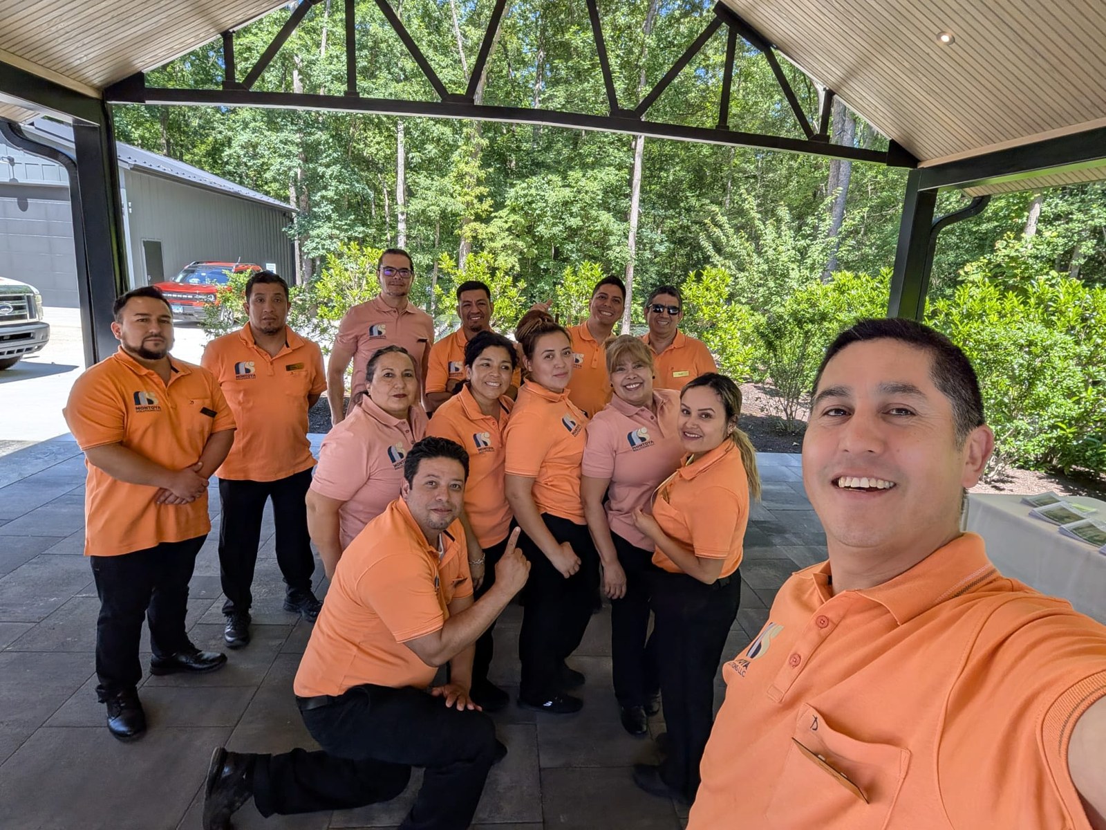 Montoya team together in their branded orange and peach polo shirts